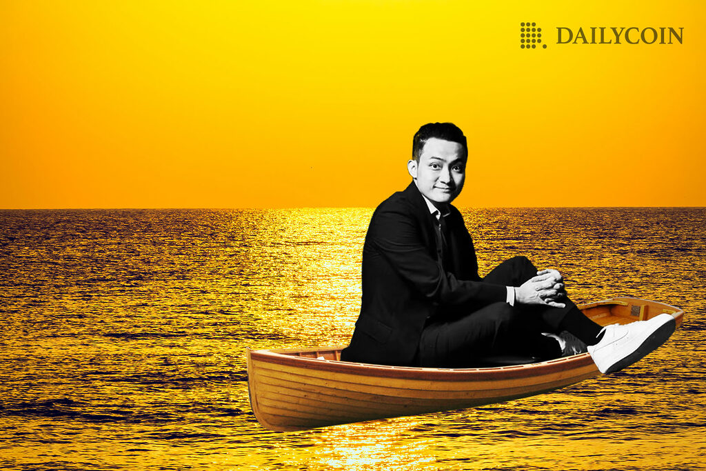 Justin Sun in a wooden boat at the ocean at sundown