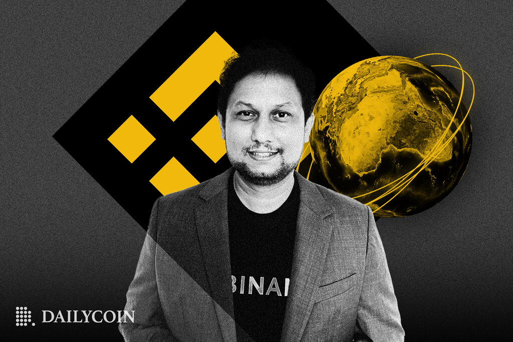 Binance Head of product Mayur Kamat stands infront of grey background with golden logo of Binance.