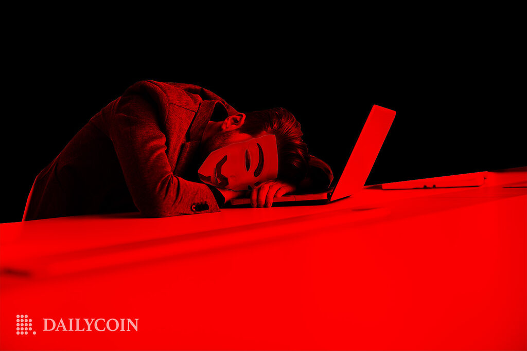 Hacker sleeping on laptop in a room lit with red light