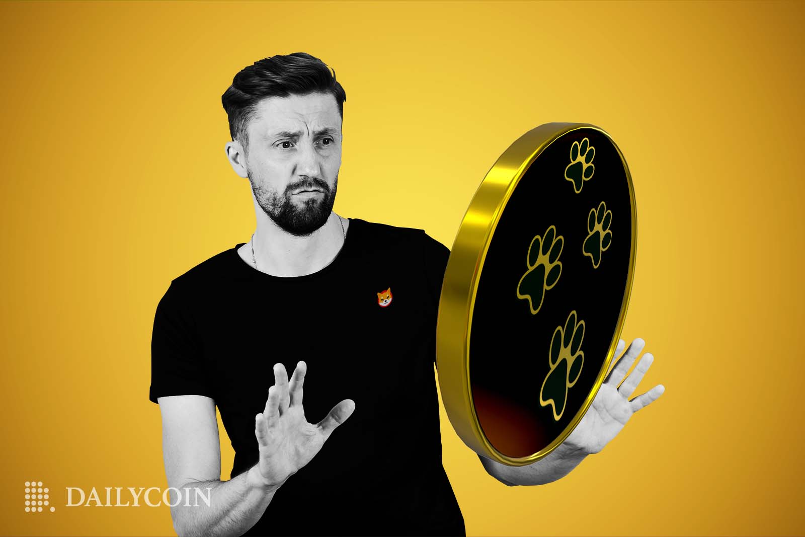 A man wearing a Shiba Inu branded black shirt holds his hands up rejenctingly to a large coin with paw prints on it.