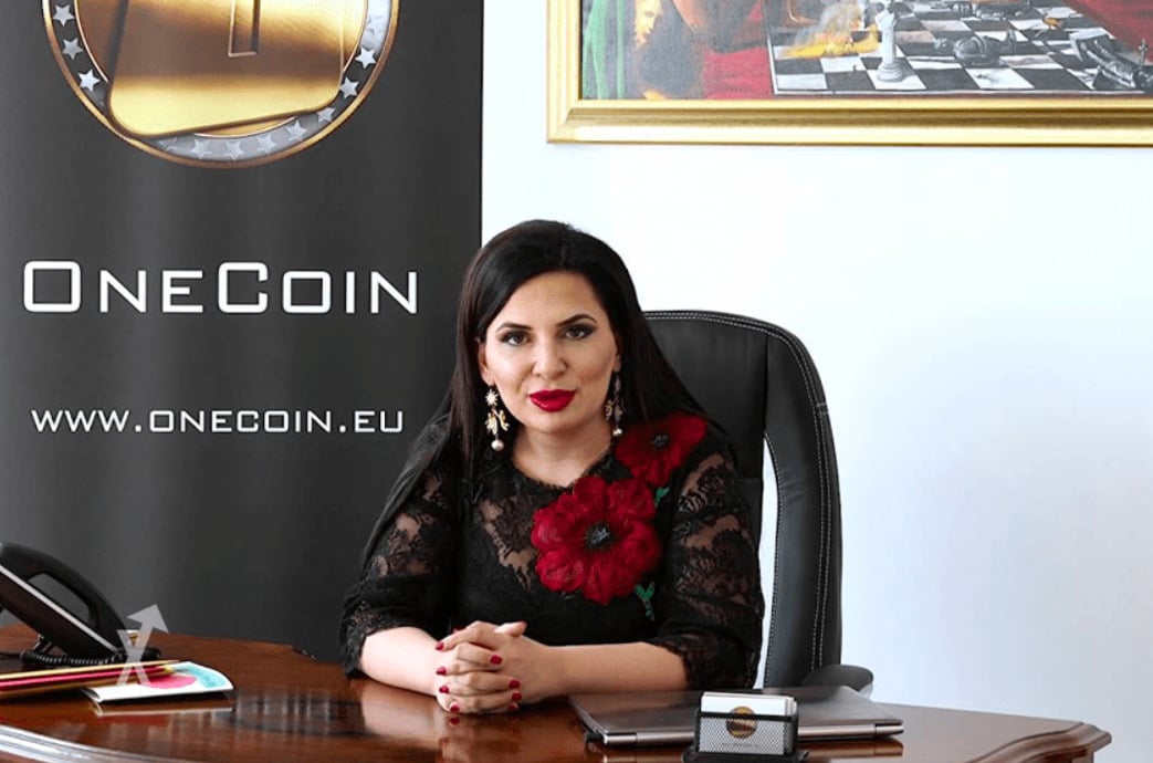 Cryptoqueen sits at desk