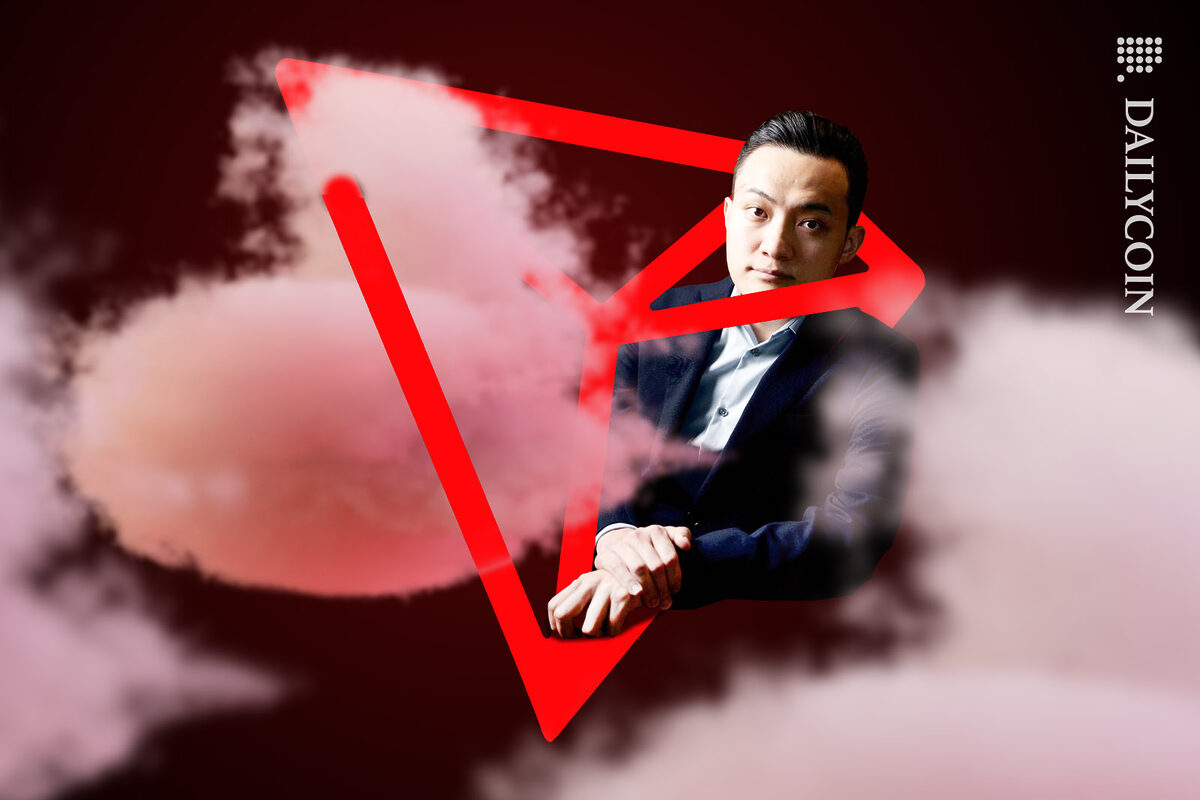 Justin sun tangled in a Tron TRX logo inside of a smoky room.