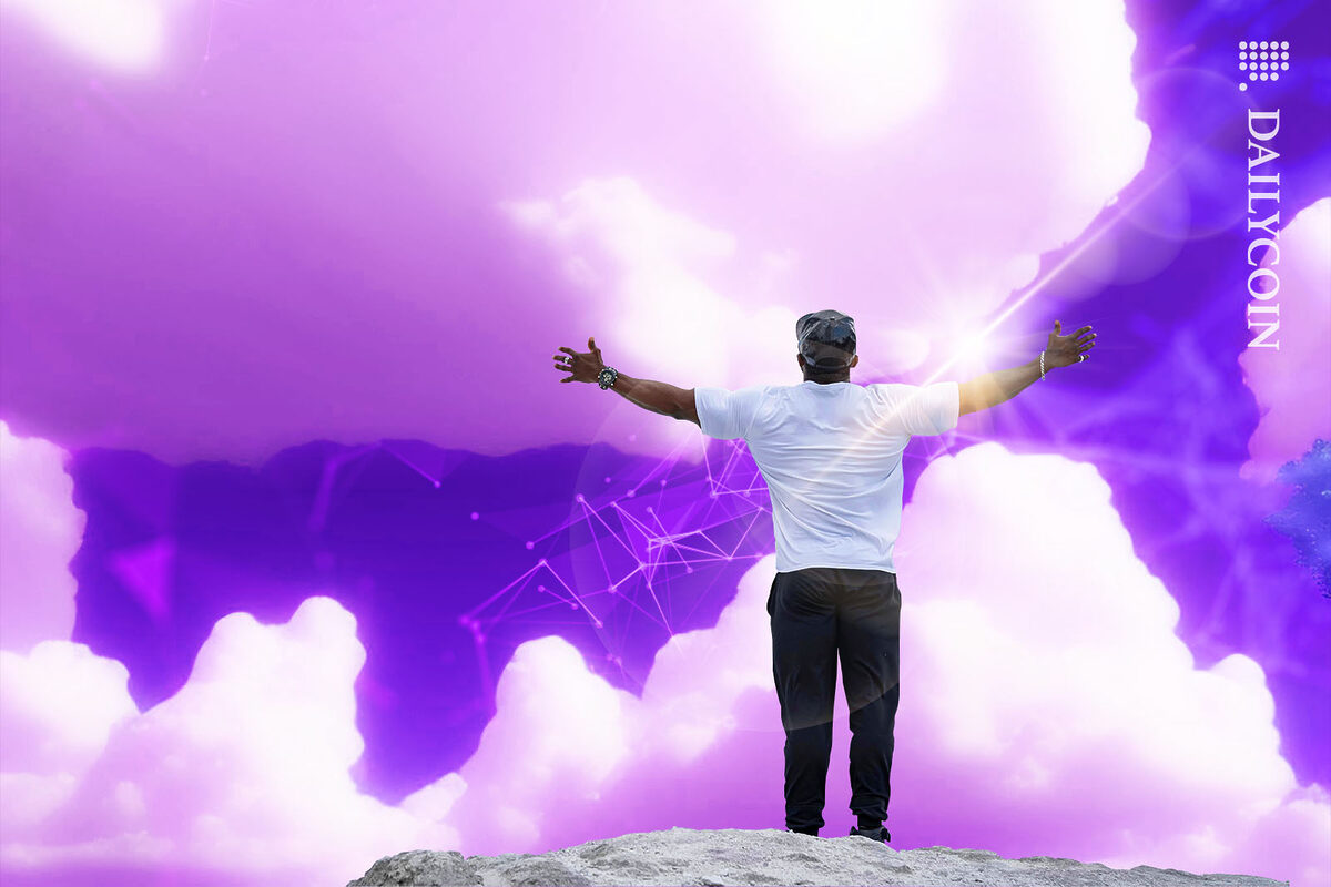 Man looking at the purple sky with open arms waiting for something from above.