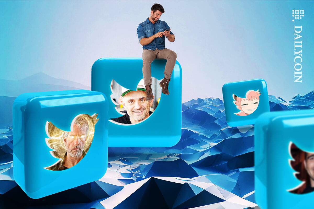 Four 3D Twitter logos with different accounts inside and a man is sitting on top of one using his mobile.