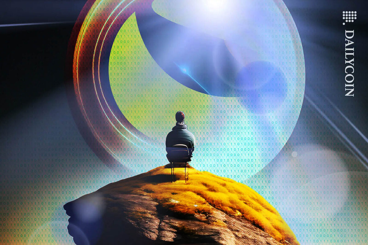 Man sitting on a chair on a hill, staring at a huge Terra Luna logo.