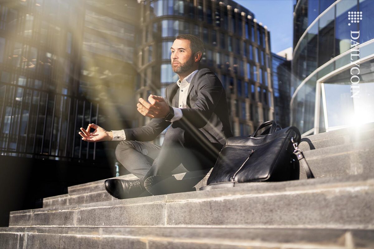 Brad Garlinghouse sitting on the stairs of a courthouse meditating.