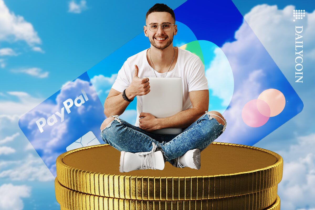 Man sitting on a tall tower of coins in the clouds next to PayPal card.