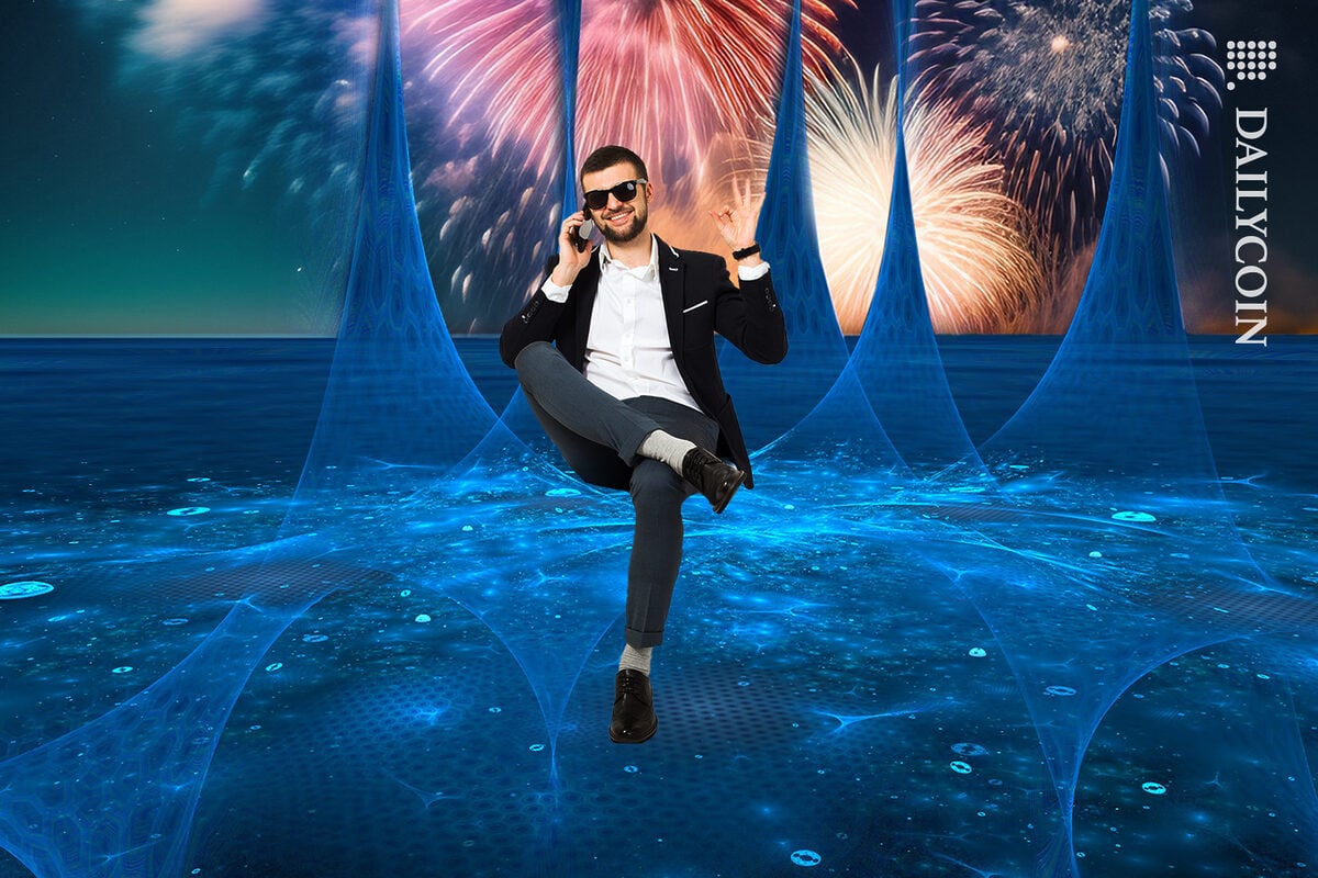 Man sitting on top of the the world, showing OK hand, fireworks behind him.