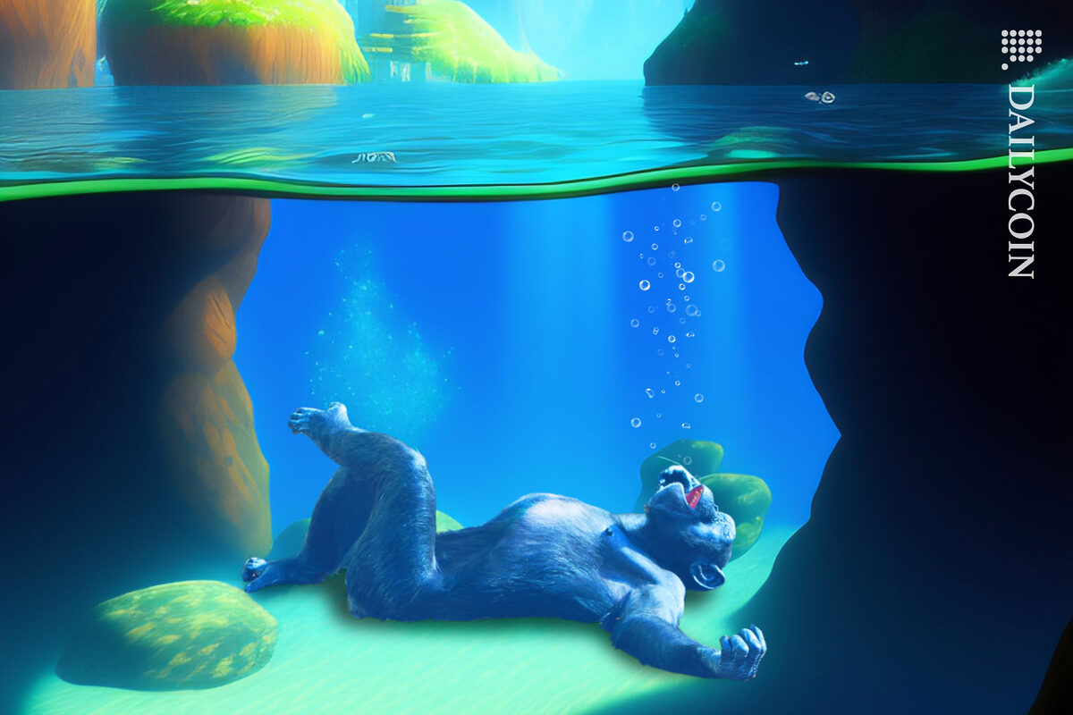A chimp laying on the bottom of the sea staring at the water's surface.