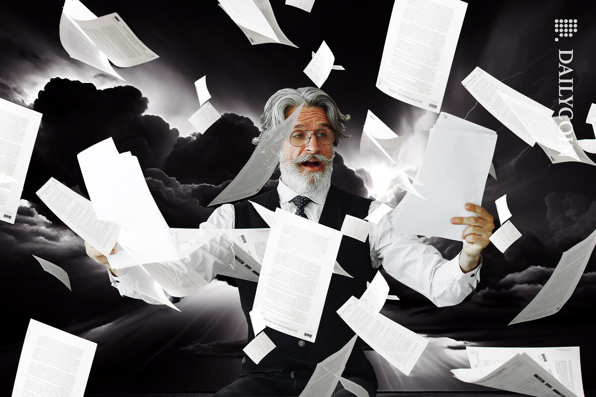 Smartly dressed man examining documents, whilst sheets of paper flying around him.