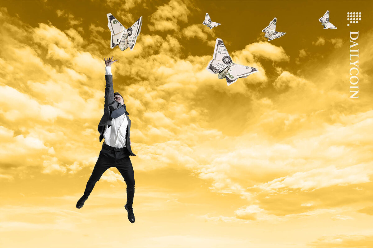 Man jumping, trying to reach an illusive butterfly made out of money.