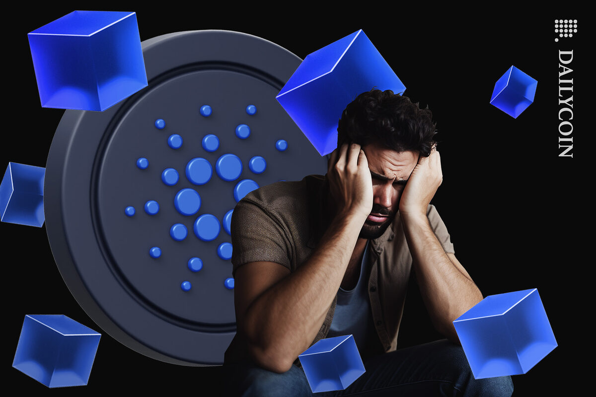 Young man feeling depressed, sitting infront of a Cardano coin and some floating blue cubes.