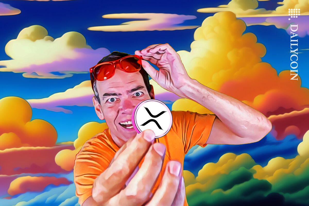 Max Kaiser holding an XRP coin looking as crazy as usual.