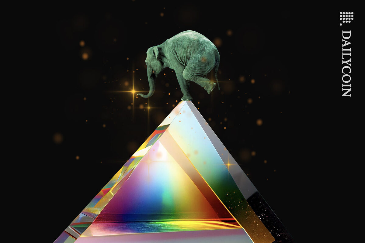 Elephant ballancing on top of a colourful glass pyramid.
