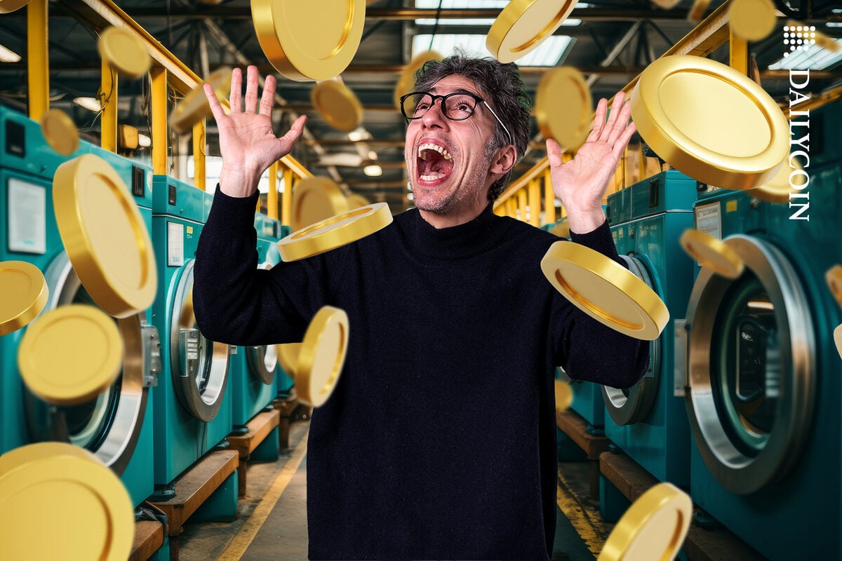 Man in a hall of Washing machines looking crazy happy with coins in the air.