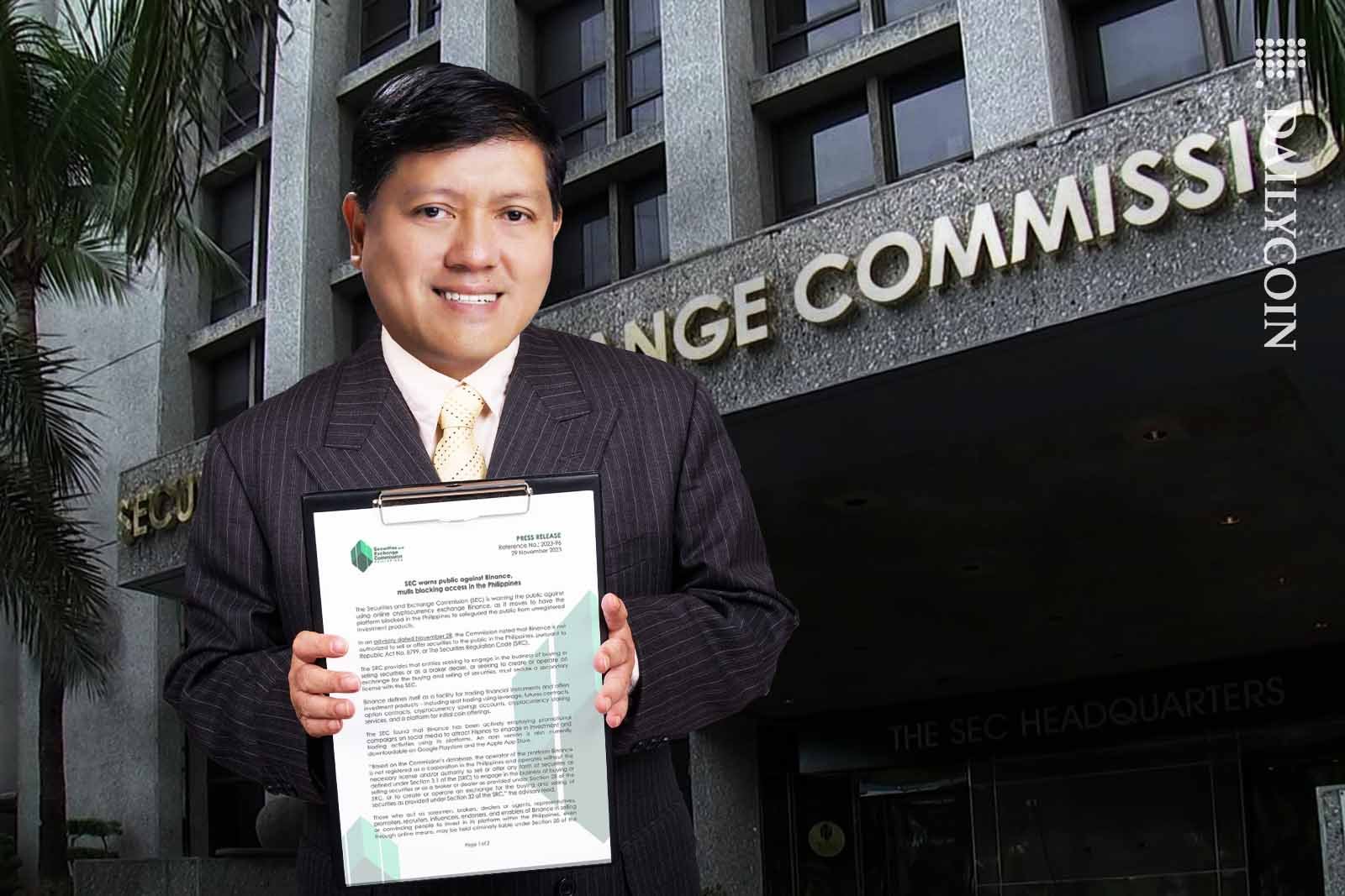 Chairman Emilio Benito Aquino holding up a document infront of the SEC building.