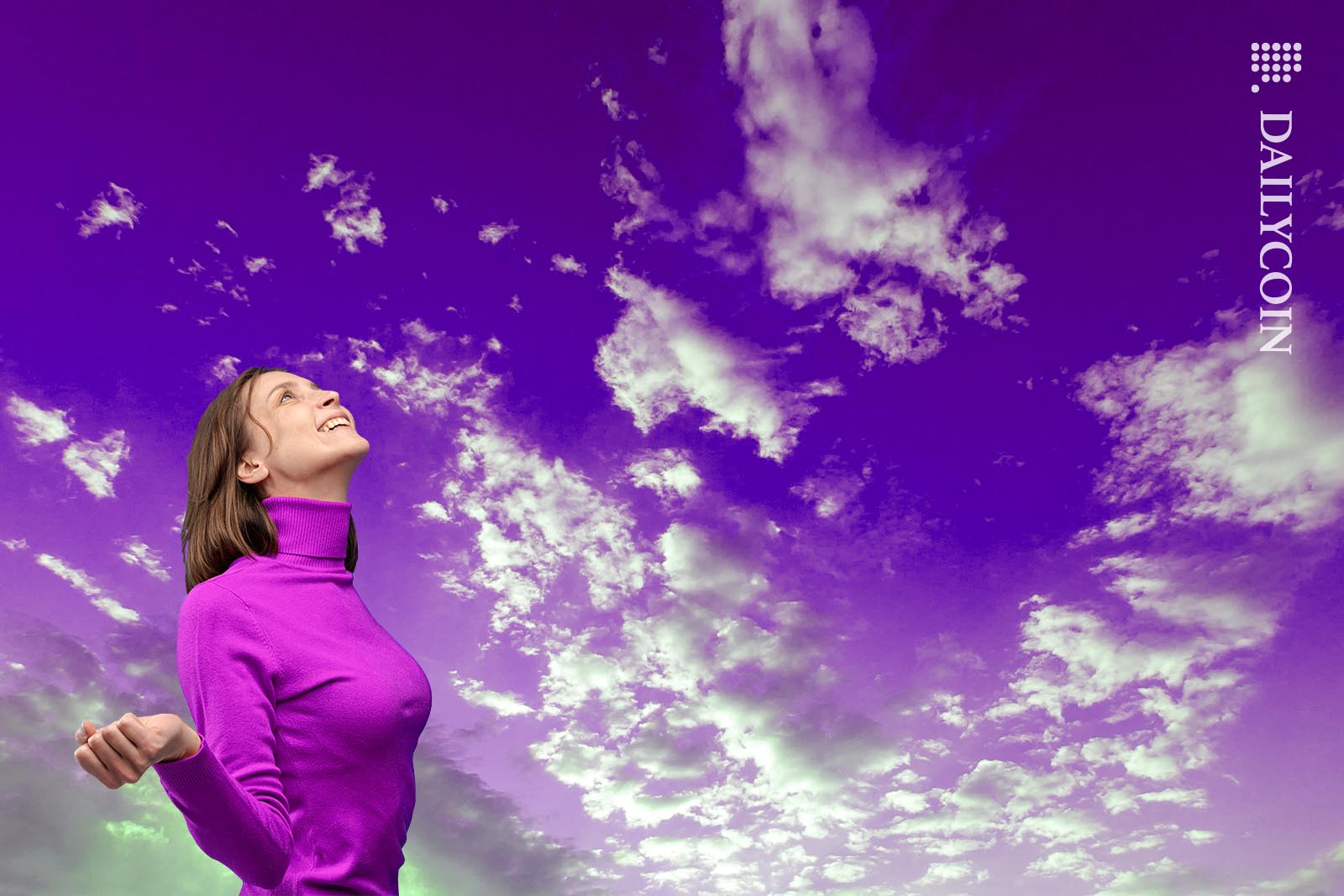 Woman wearing a purple jumper looking up to the sky anticipating an airdrom from a purple sky.