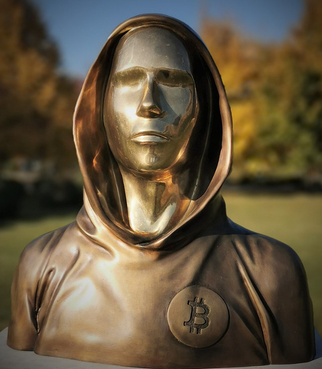 Golden statue wearing a hoodie with Bitcoin logo on it.