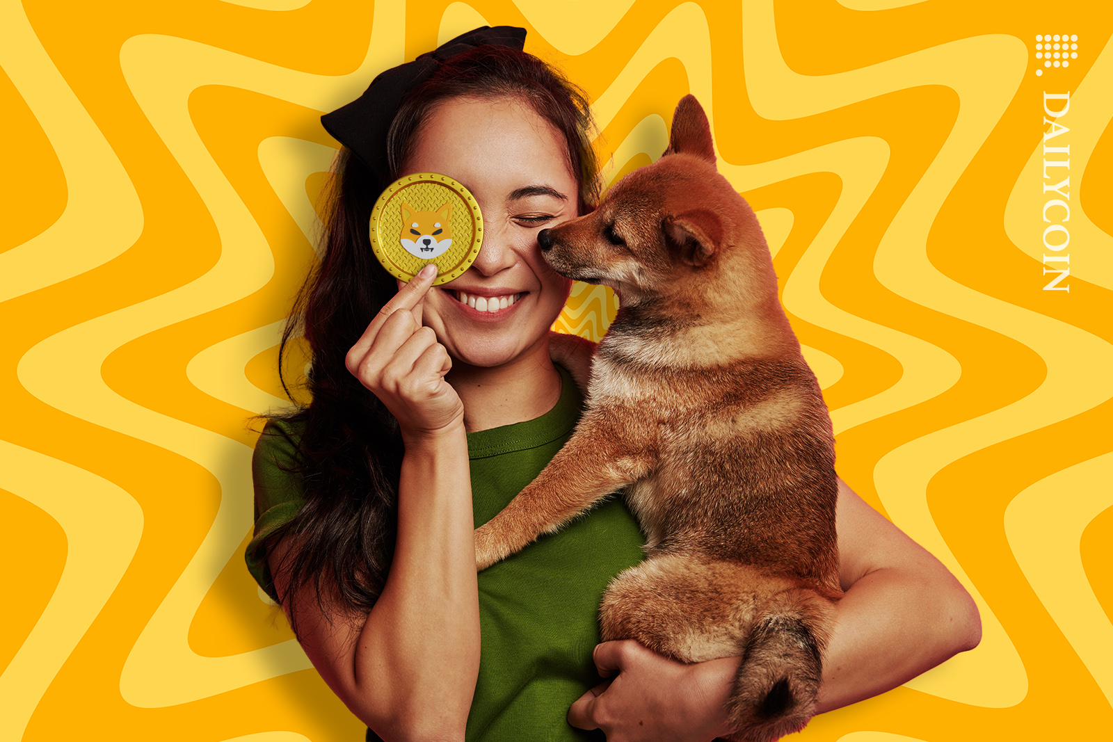Girl holding a shiba inu puppy and a shib token by her eye smilling.
