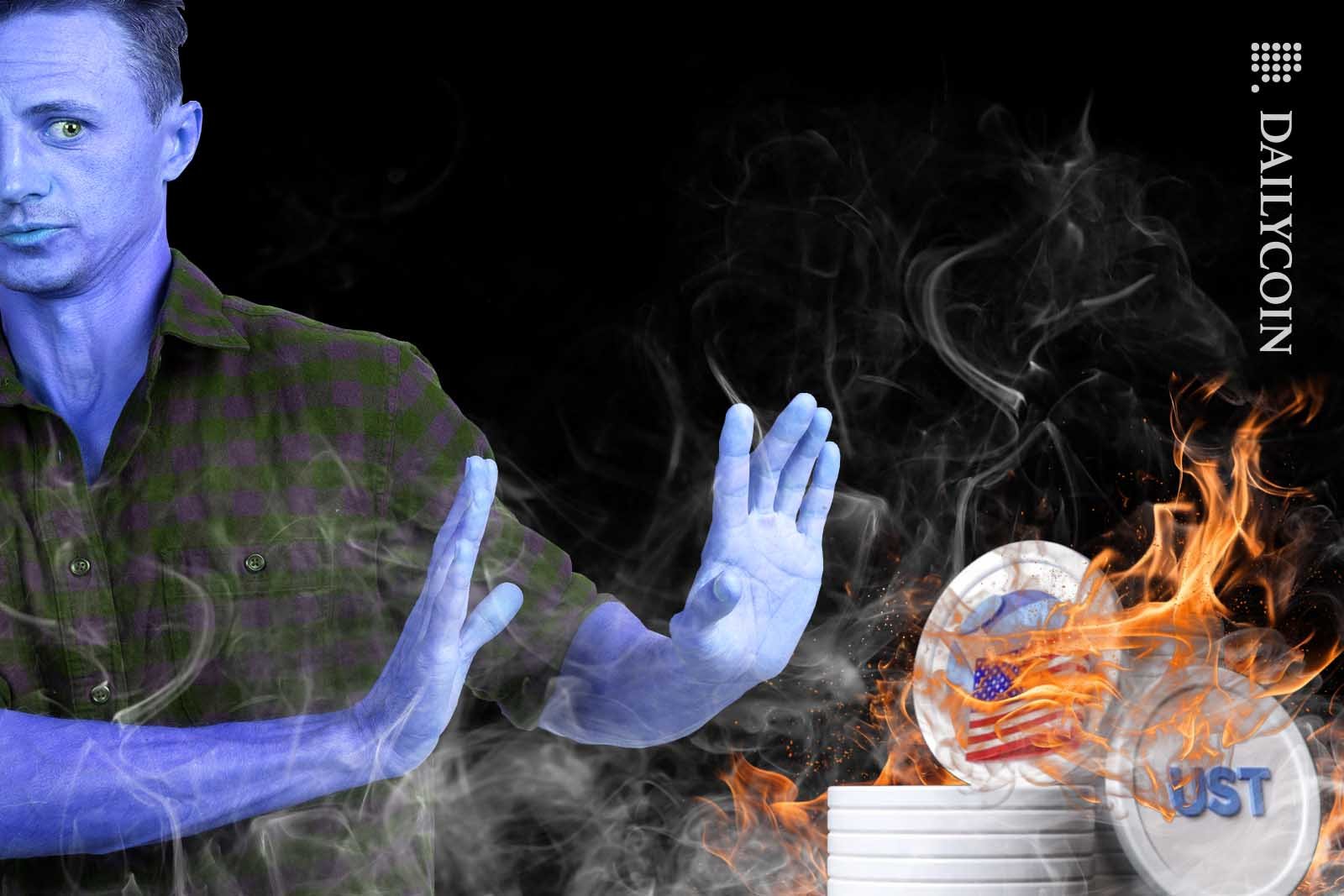Blue man trying to deny the existance of a pile of burning UST coins next to him.