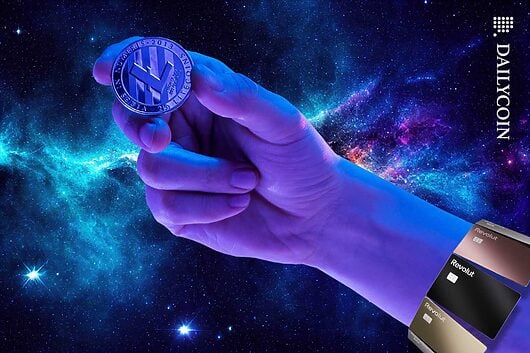 Hand holding a Lite coin surrounded by Revolut cards.