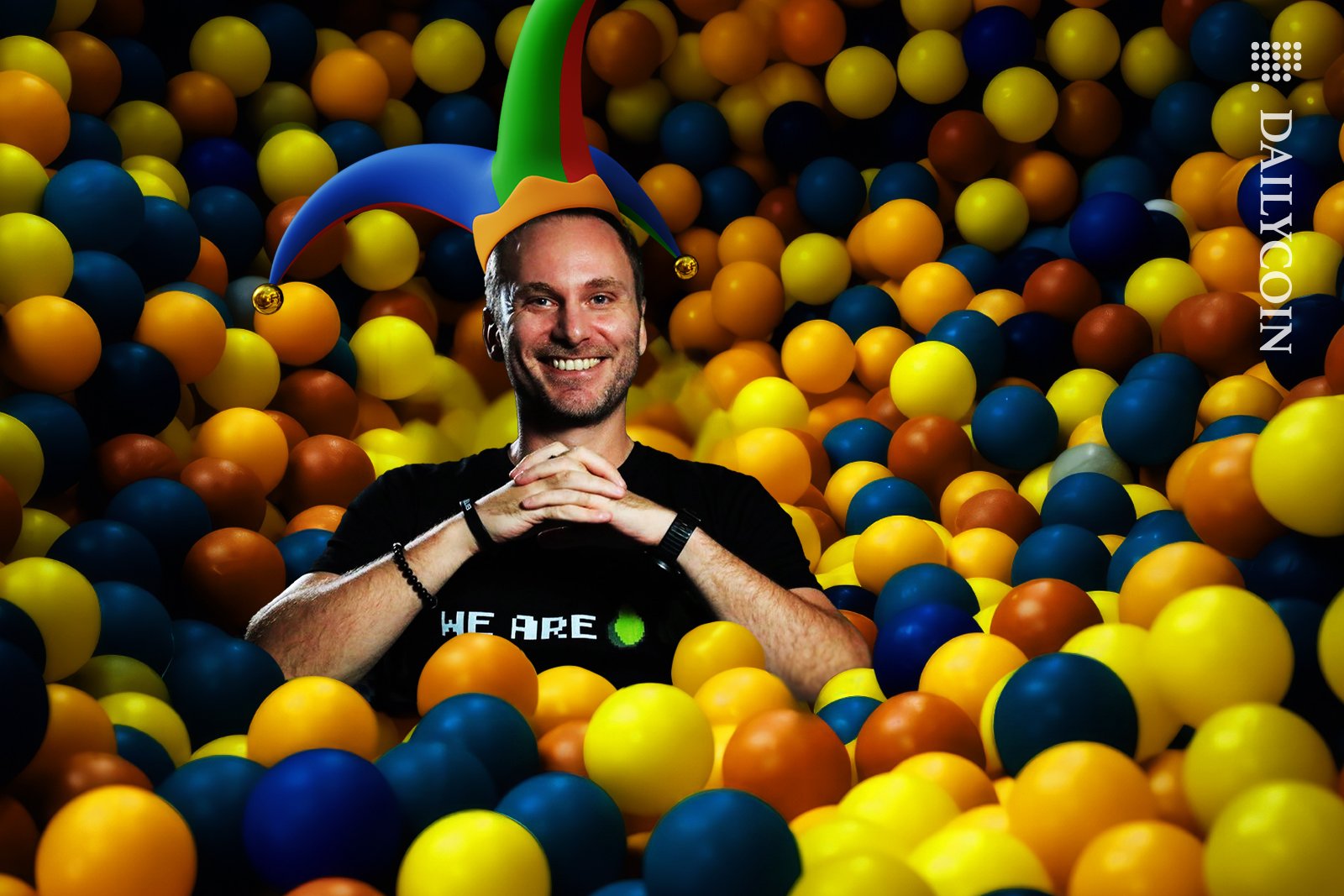 Tether ceo Paolo Ardoino dressed as a jester playing around in the ball pit.
