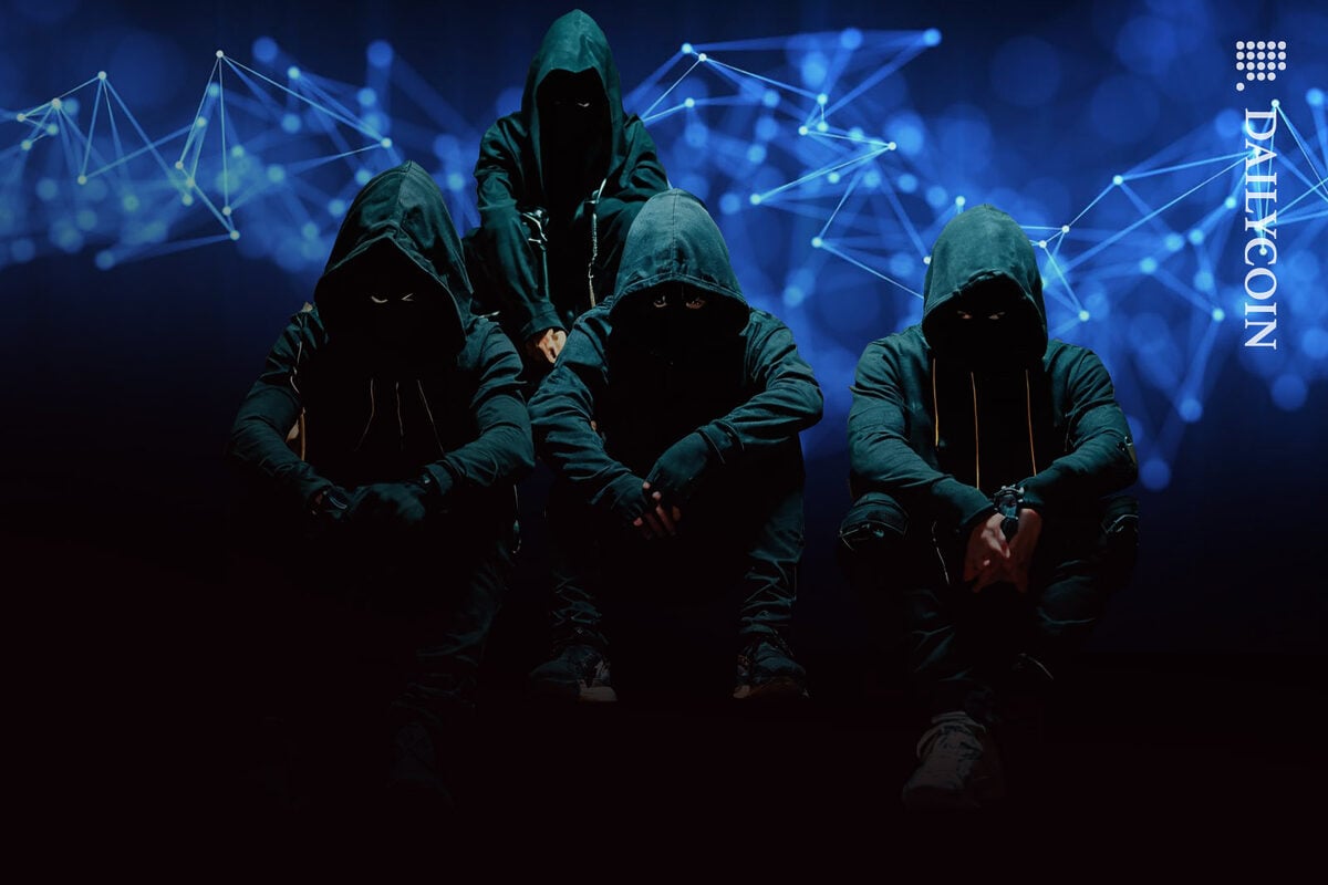 Four scary looking hooded figures sitting on stairs with blockchain graphics behing.