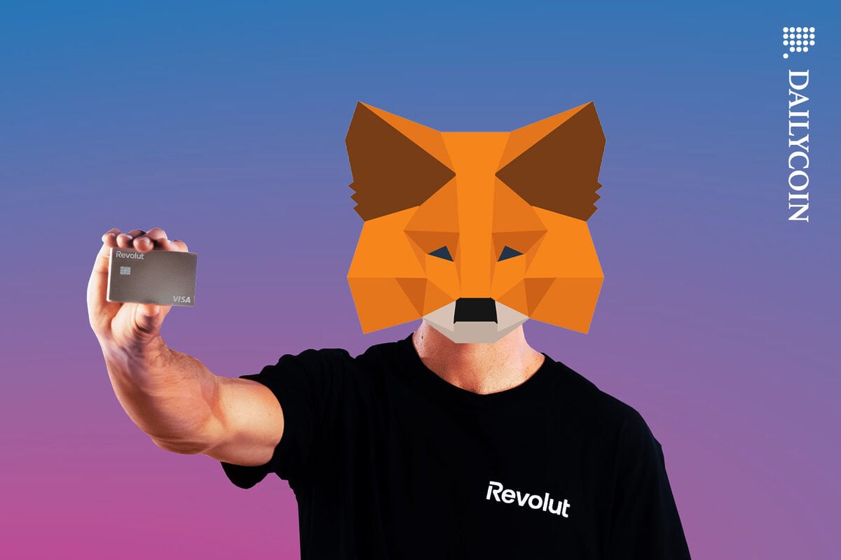 Man holding a Revolut card wearing a metamask.