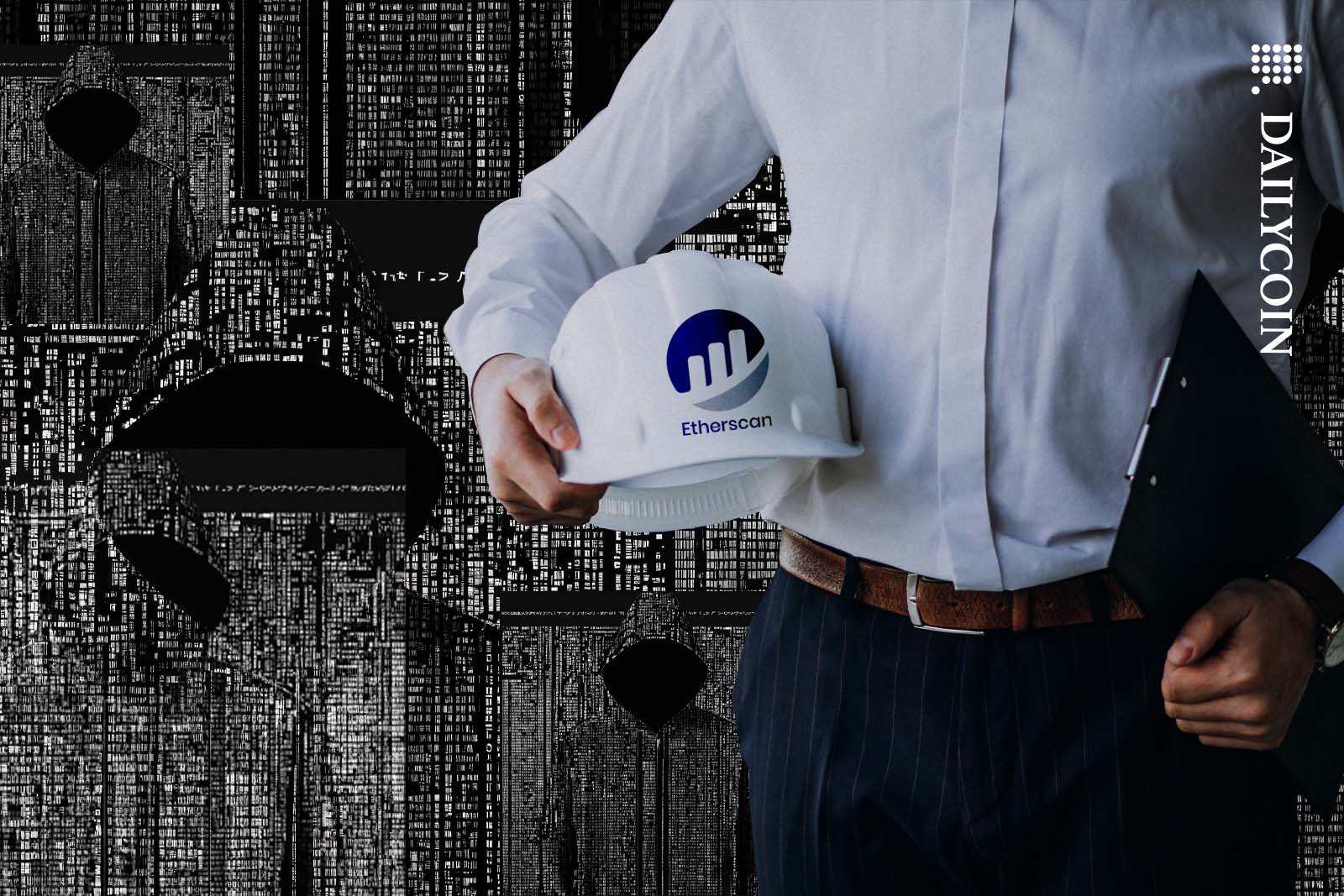 Health and safety officer holding a hard hat with a Etherscan logo on it.