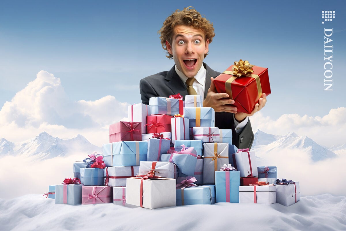 Guy holding a gift in a pile of other presents.