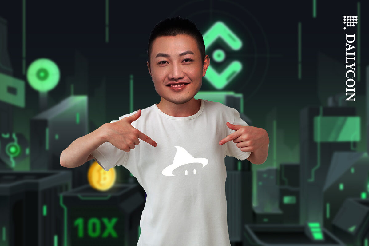 Johhny Lyu pointing at his T-shirt with an ELFi Protocol logo on it.