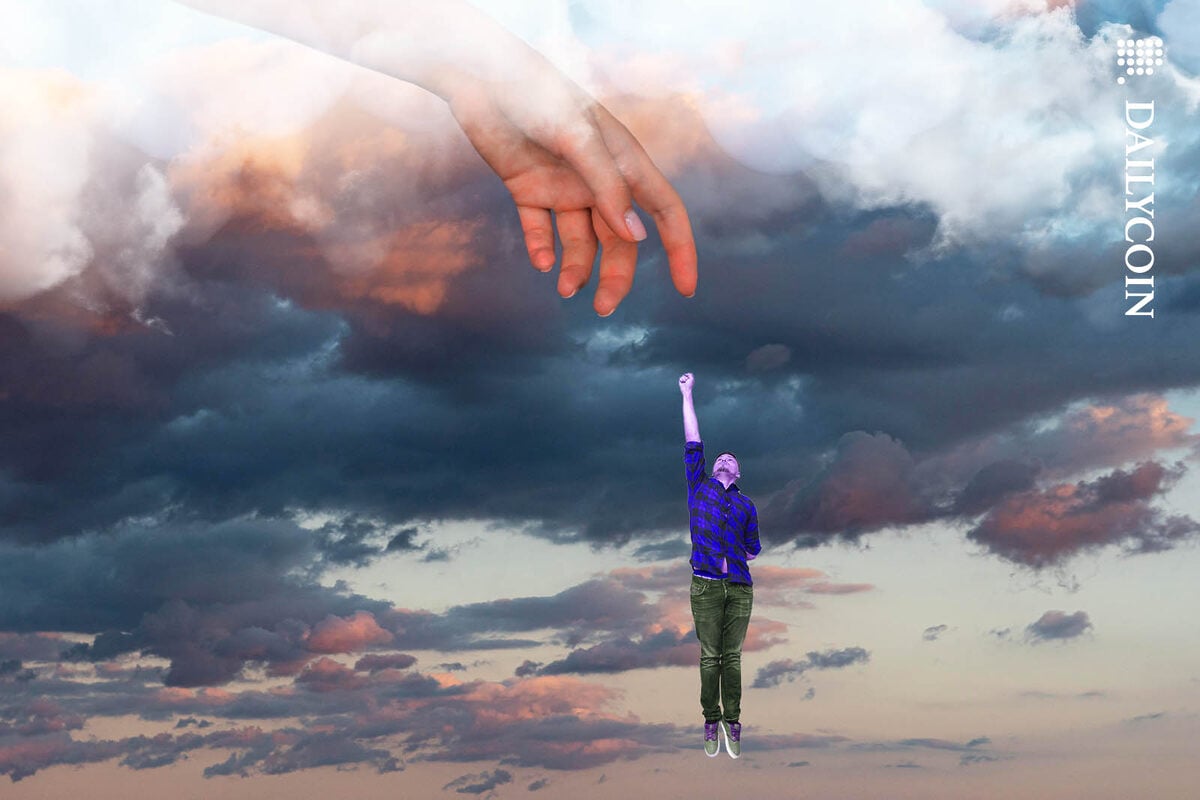 Man flying towards a giant hand in the sky.