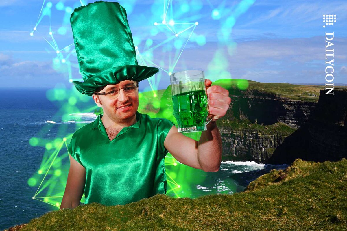 Krisz Marszalek raises his green pint as he appears from behing the Irish coast.
