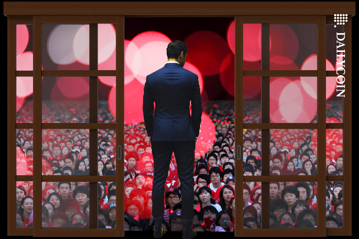 Man in suit standing in an open door staring at a huge crowd of chinese people.