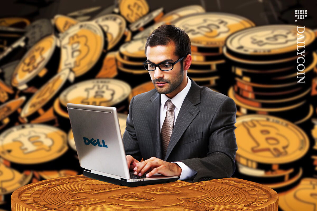 Bitcoin enthusiast sitting with a Dell laptop.