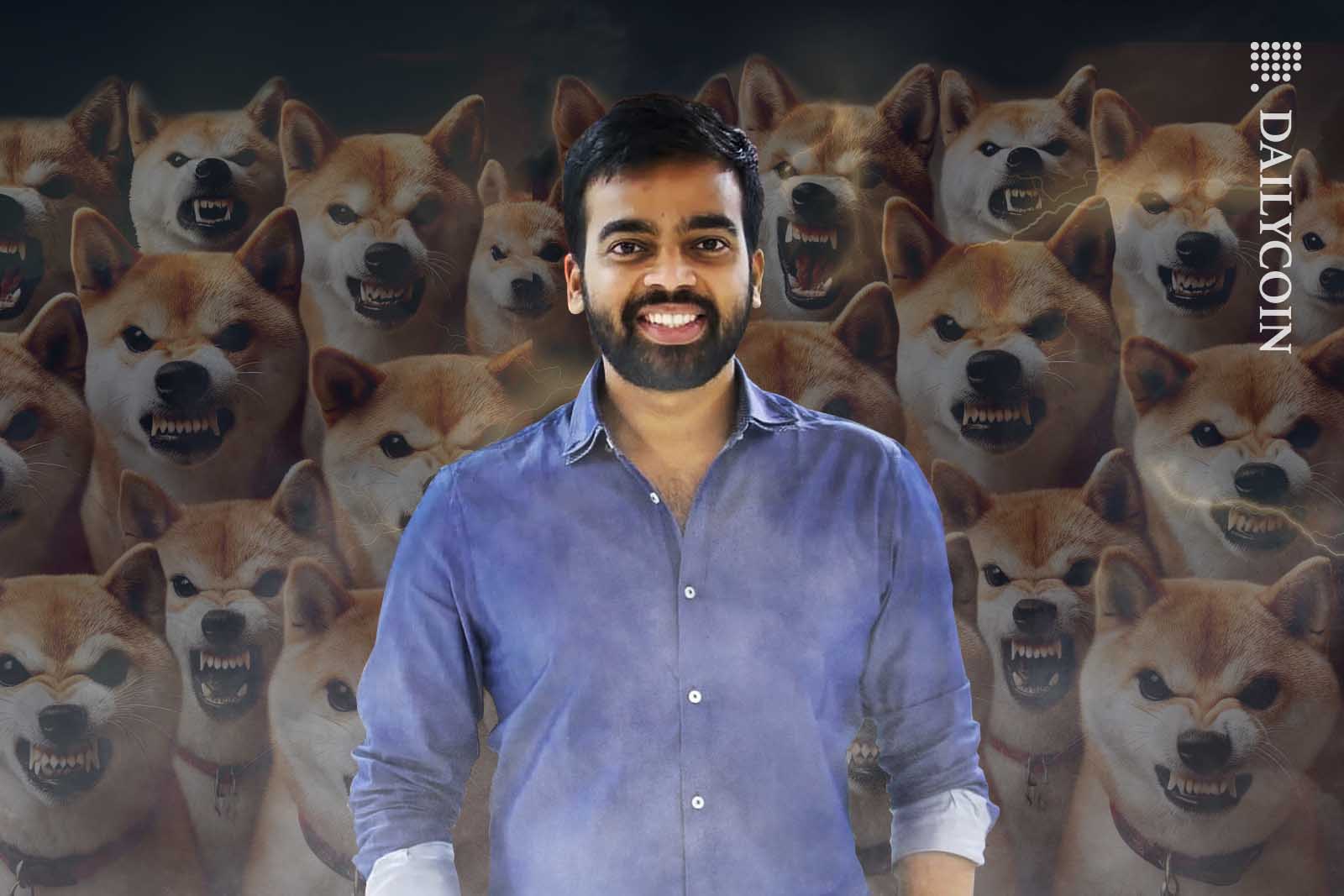 Nischal Shetty of WazirX smiling in the forefront, with many angry Shiba Inus in the background.
