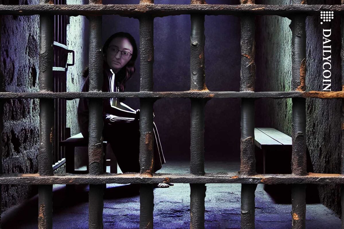 Caroline Ellison sitting in a dark and dingy prison cell.