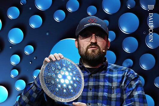 Charles Hoskinson holding up Cardano ADA coin.