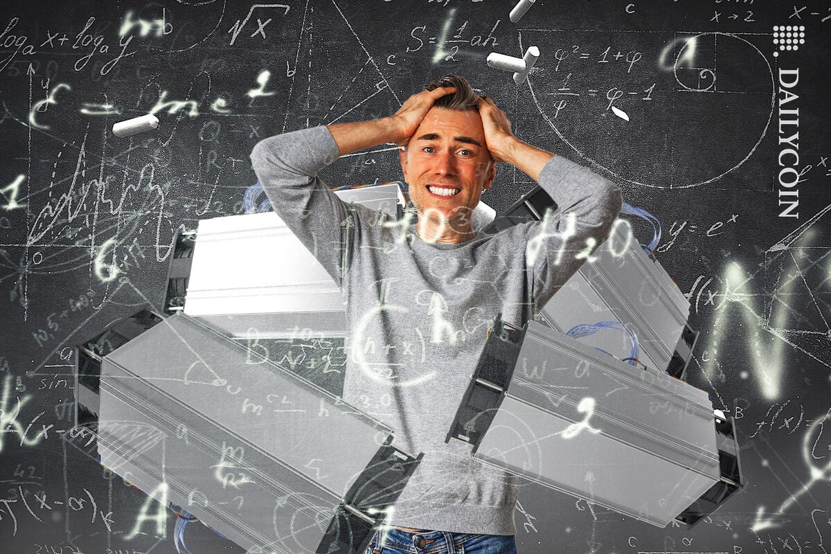 Man surrounded by crypto mining rigs and maths calculations and he is holding his head.