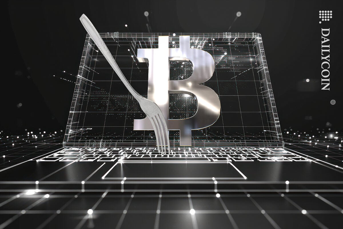 Bitcoin on a digital computer screen with a fork on the keyboard.