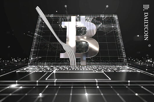 Bitcoin on a digital computer screen with a fork on the keyboard.
